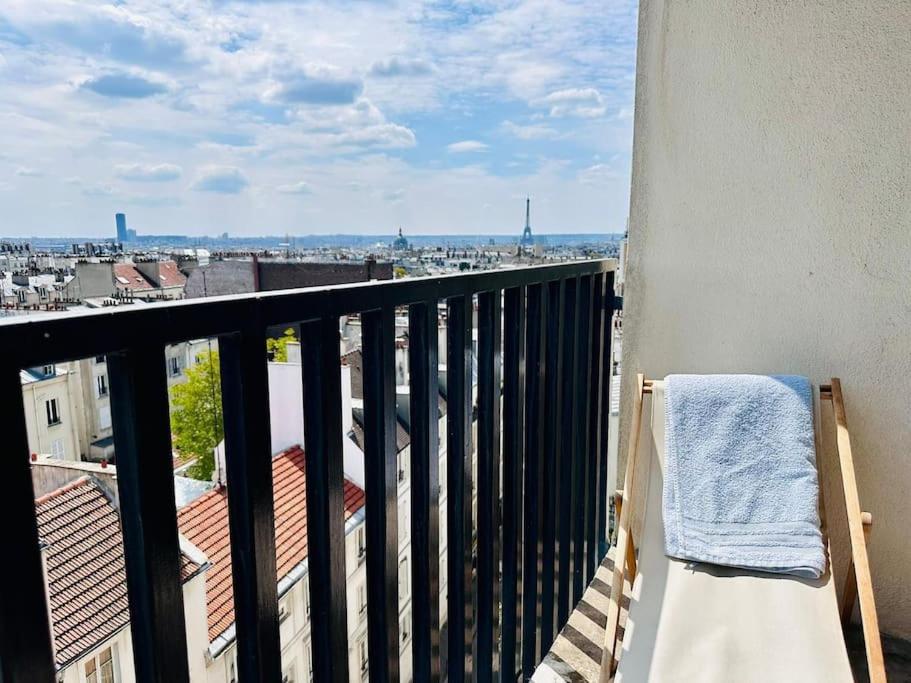 un balcon avec une serviette et une vue sur une ville dans l'établissement FLAT with TOUR EIFFEL view and Montmartre, à Paris