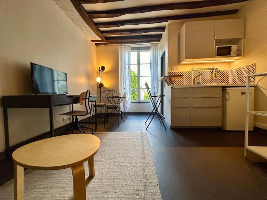 un salon avec une cuisine et une table dans l'établissement Studio St Merry - Fontainebleau, à Fontainebleau