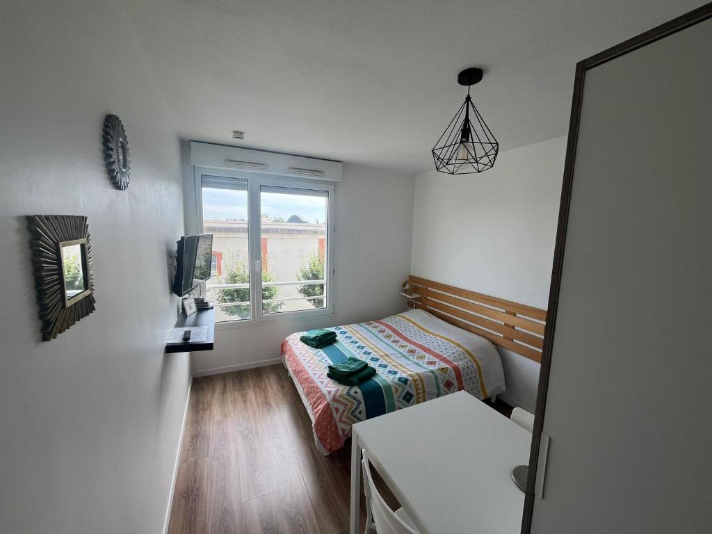 une petite chambre avec un lit et une fenêtre dans l'établissement Studio 306 - Gare - Arena - centre Reims, à Reims