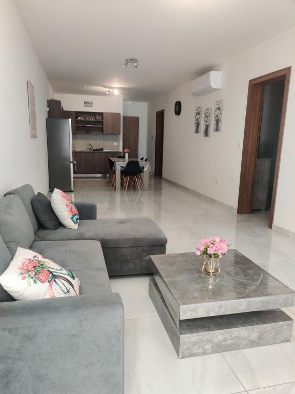 a living room with two couches and a table at Bella Qawra Maisonette in St. Paul's Bay