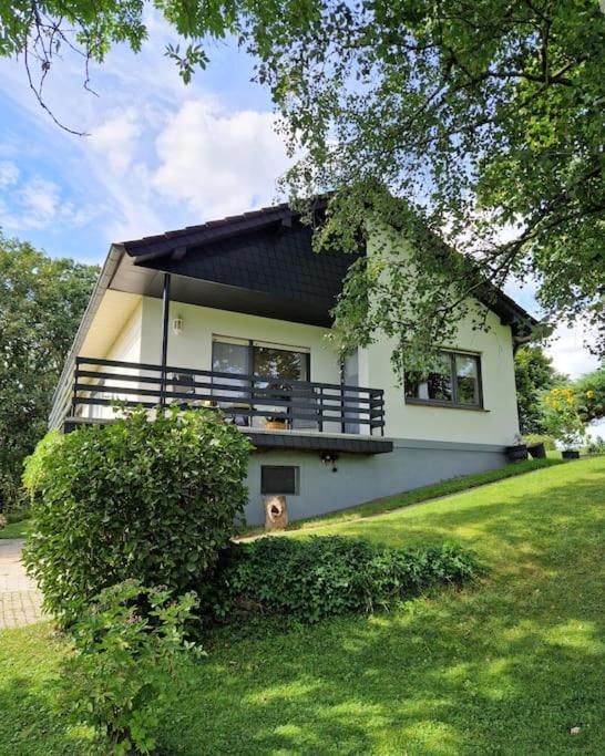 a dog sitting in front of a house at Ferienwohnung Grüne Auszeit in Nideggen