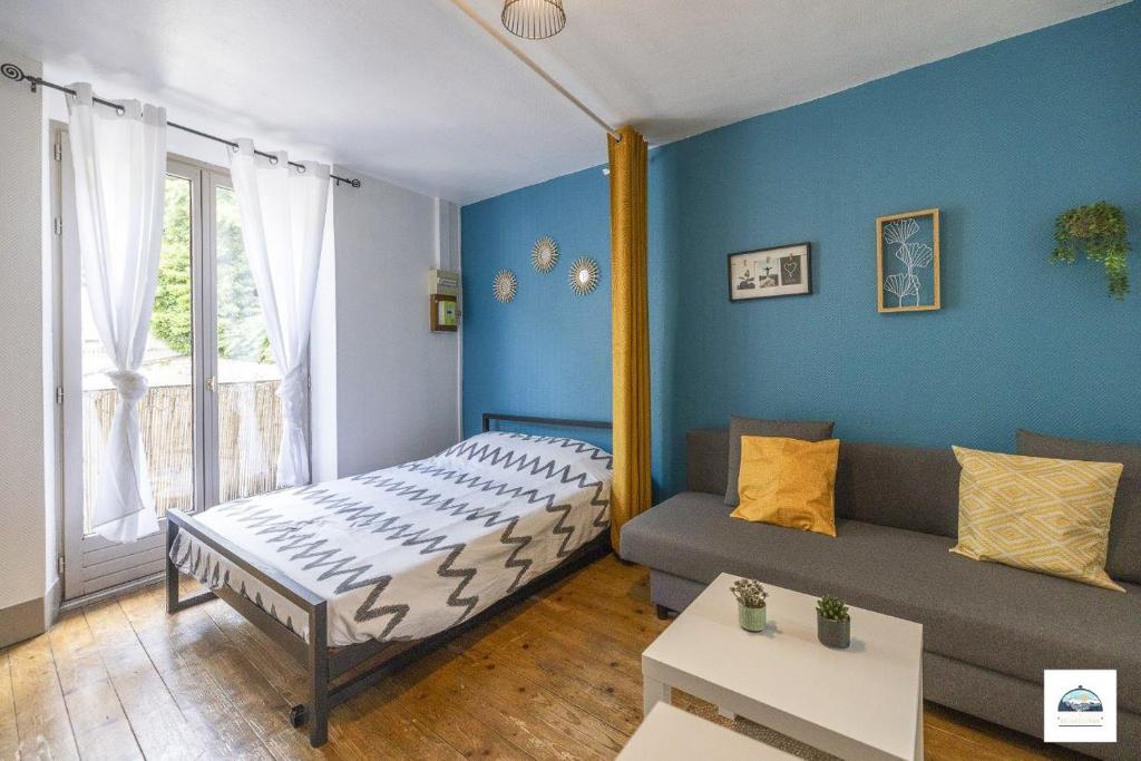 une chambre avec un lit et un canapé dans une pièce dans l'établissement Lescapade Hospitalière, à La Tronche