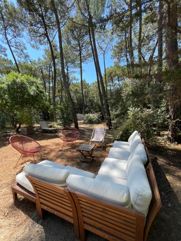 - un canapé et des chaises dans une cour arborée dans l'établissement La palmyre Villa individuelle dans Parc privée Accès Plage tennis, à La Palmyre