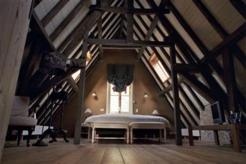 a large attic room with a bed and a window at B&B 1669 in Bruges