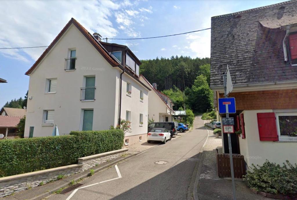 a street with a white house and a car parked on the street at Ferienwohnungen Steiert in Freiburg im Breisgau
