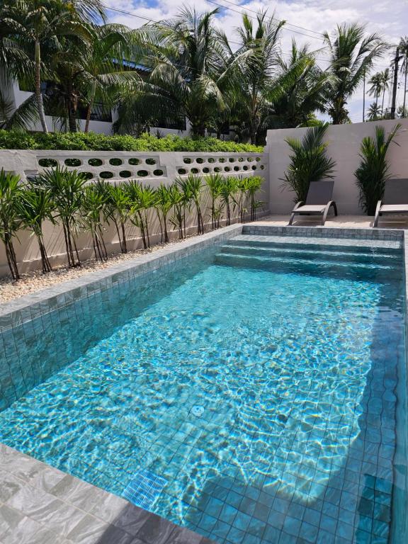 ein Schwimmbad mit blauem Wasser in einem Ferienort in der Unterkunft Nai Harn beach Villa 2 bdr in Rawai Beach
