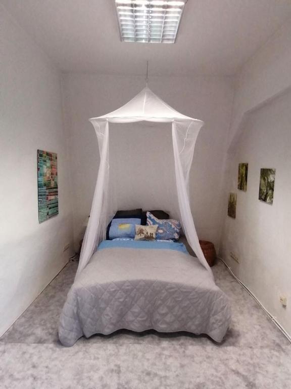a bed with a canopy in a white room at Nr 5 Doppelzimmer mit Talblick in Annaberg-Buchholz