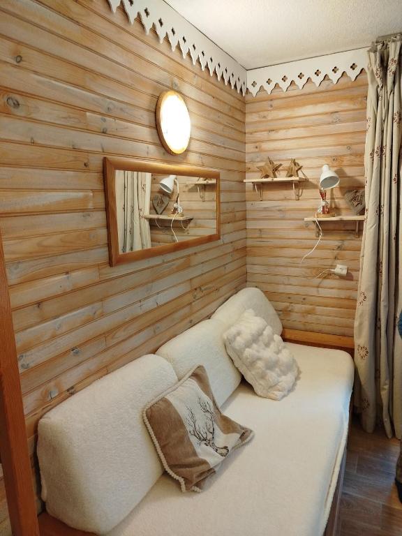 un salon avec un canapé et un miroir dans l'établissement Studio chaleureux et cosy, à Valfréjus