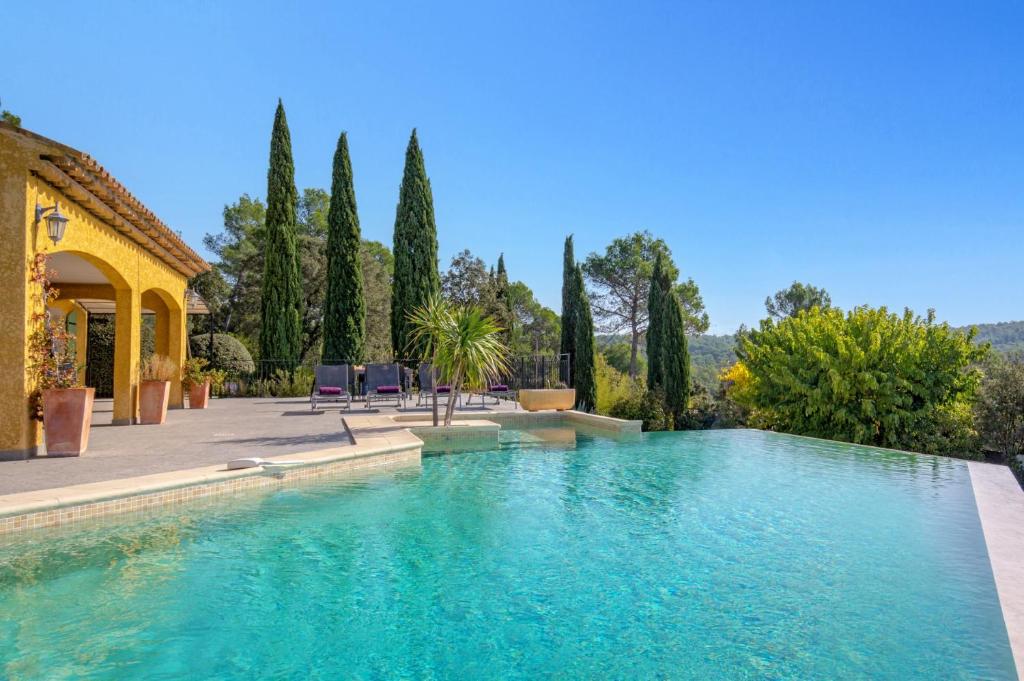 une piscine devant une maison avec des arbres dans l'établissement Villa Les Etoiles by Villa Plus, à Lorgues