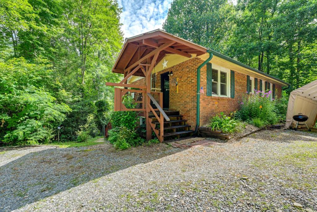 a small brick house with a porch and stairs to the door at Unique and Artsy Cabin with Mountain Views! in Robbinsville