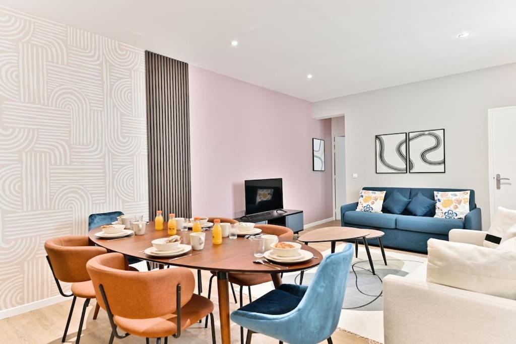 un salon avec une table, des chaises et un canapé dans l'établissement Appartement spacieux près de Paris - II, à Bagnolet