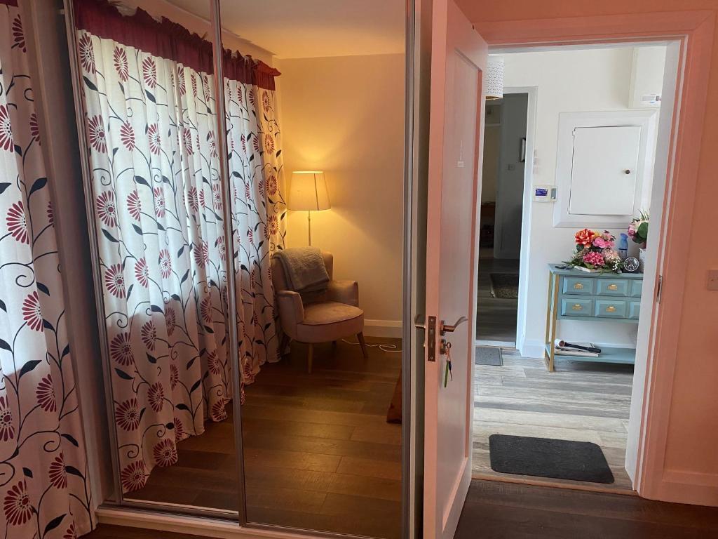a glass door leading into a room with a chair at Kilmactrasna Cottage in Carrickmacross