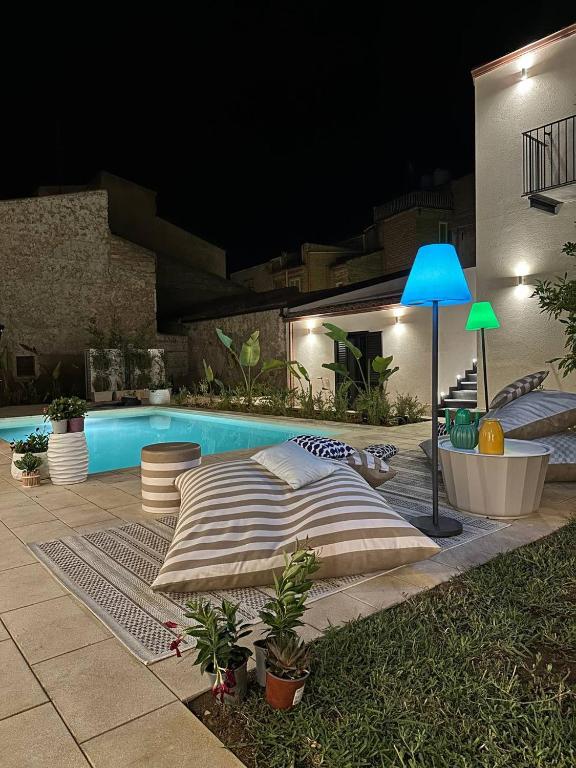 a bed sitting next to a swimming pool at night at B&B Case Marcapane in Sommatino
