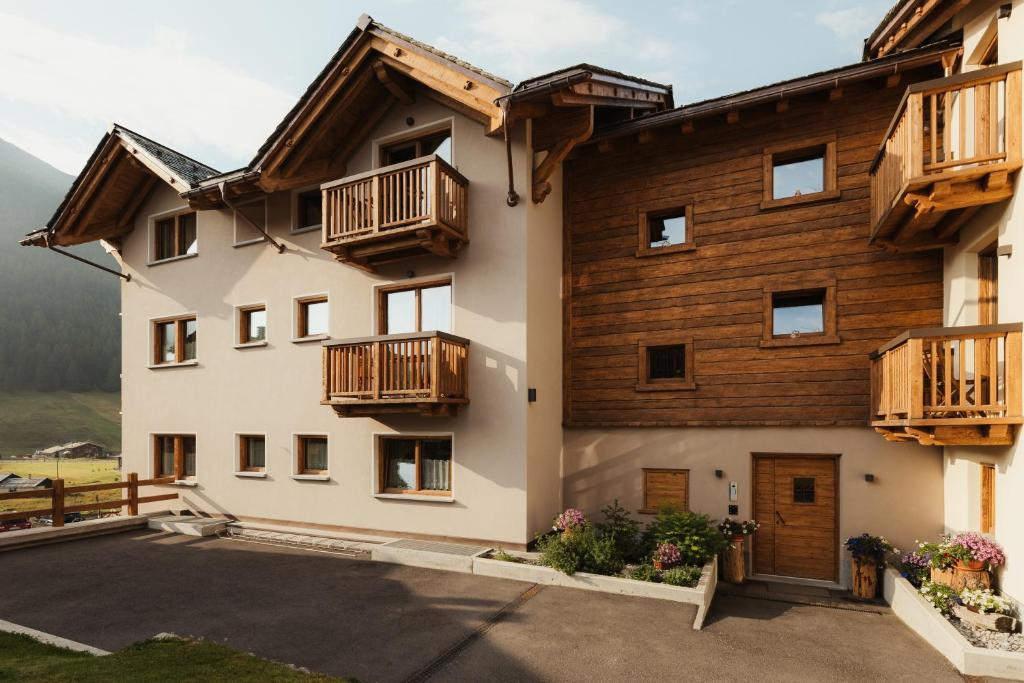 a house with wooden balconies on the side of it at Bonvivar -- Mountain Guesthouse in Livigno