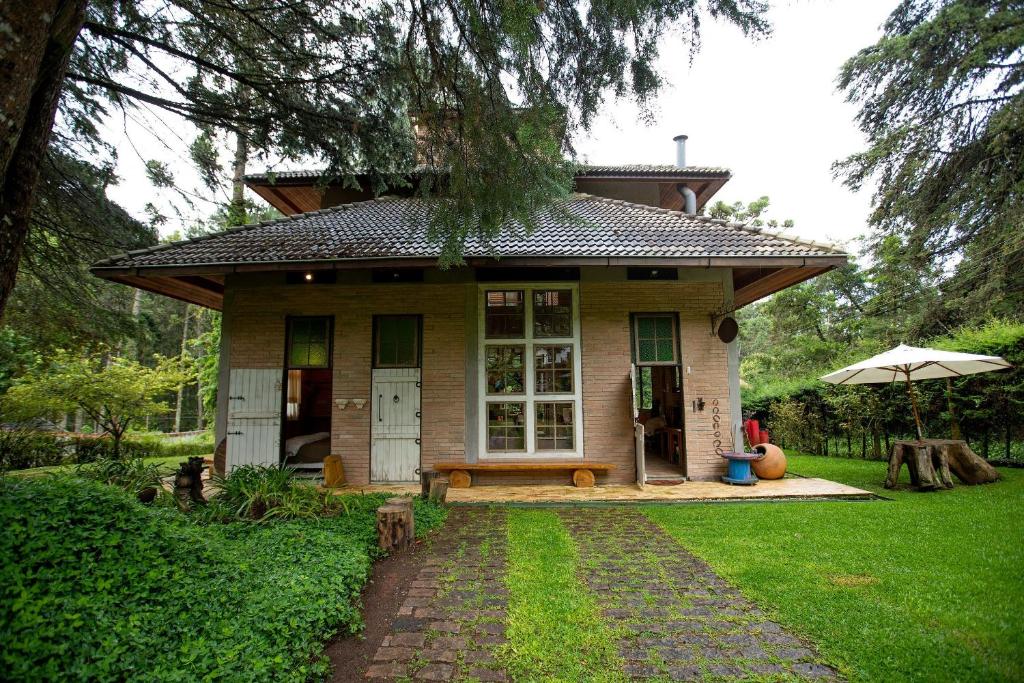 a small house with an umbrella in the yard at Design Home by The Lodges in Campos do Jordão