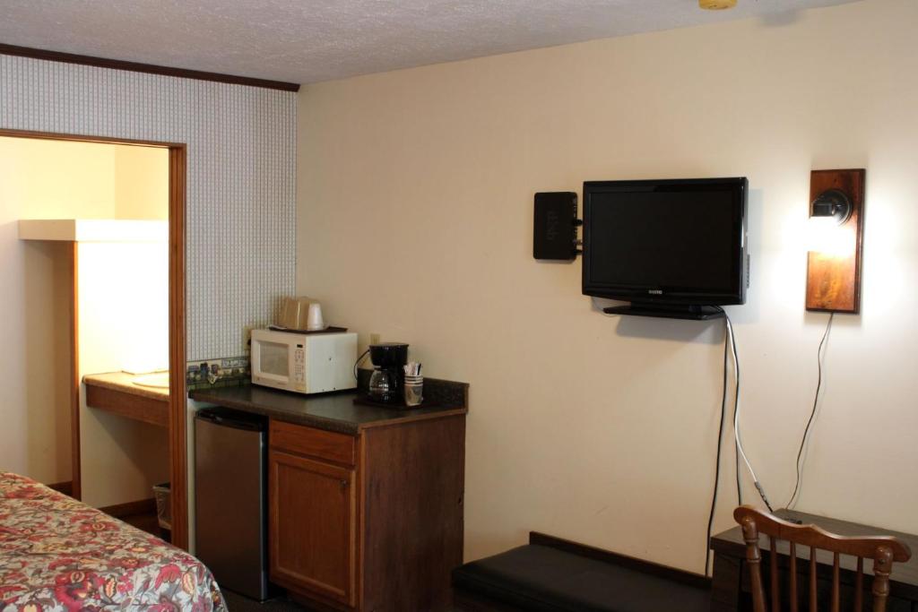 a hotel room with a bed and a tv on the wall at Two Rivers Lodge in Bryson City