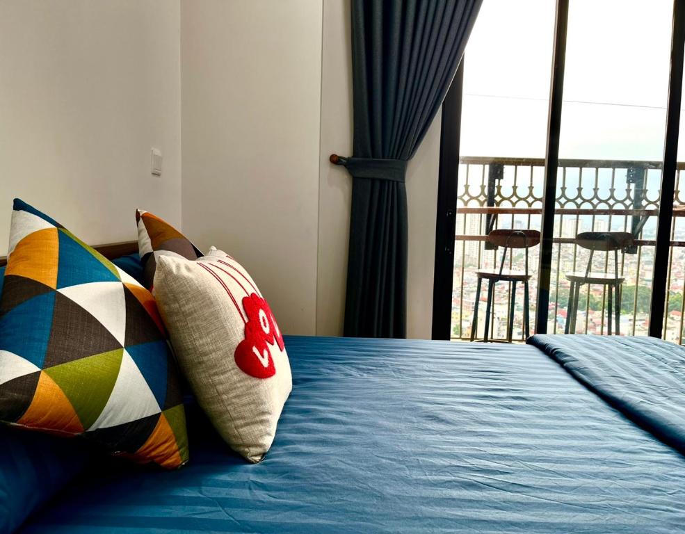 a bedroom with a bed with pillows and a balcony at HT Home D'el Dorado 1 in Hanoi