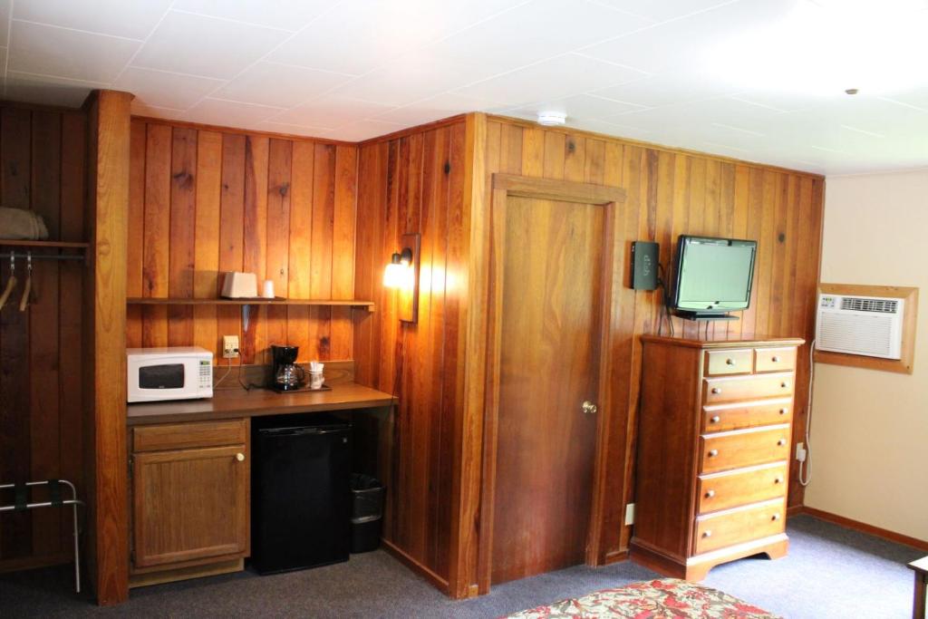 a room with a kitchen with a desk and a microwave at Two Rivers Lodge in Bryson City