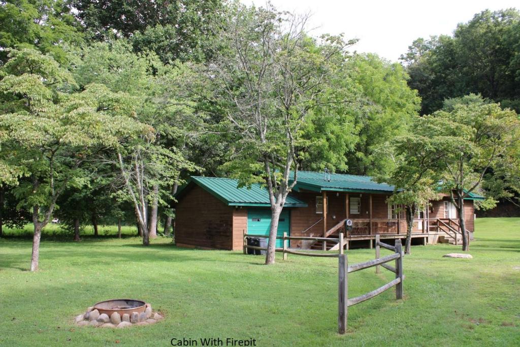 a cabin in the woods with a fire pit in the yard at Two Rivers Lodge in Bryson City