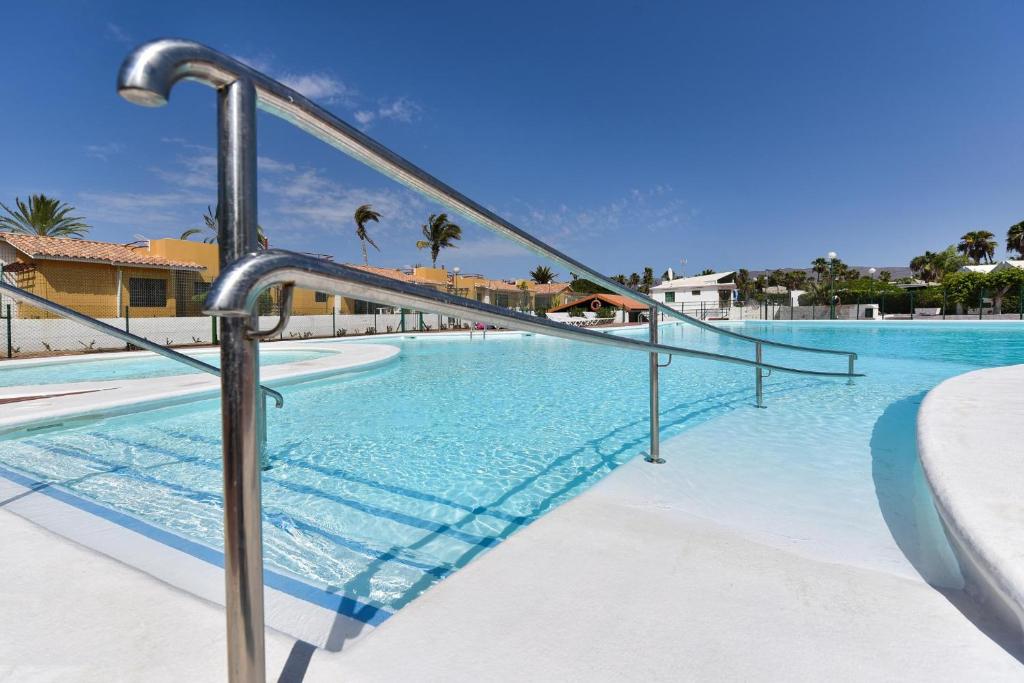 a swimming pool with aicrobialicrobialicrobialicrobialicrobialicrobialicrobialicrobialicrobial at Cozy Bungalow Playa Flor Maspalomas by VillaGranCanaria in Maspalomas