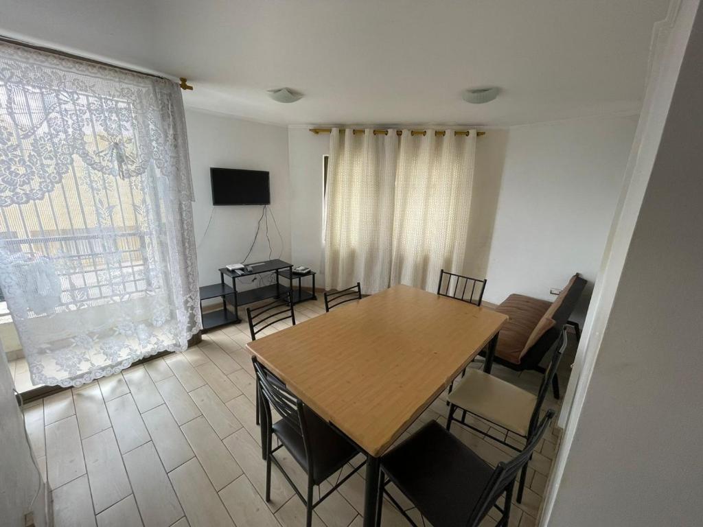 a dining room with a wooden table and chairs at Edificio INMOBILIA - Av Argetina 2 dormitorios in Antofagasta