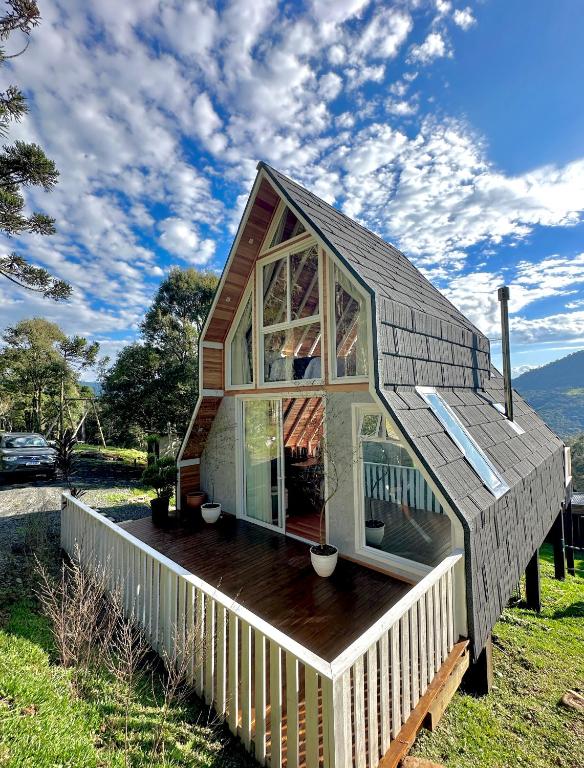 a small house with a roof on a deck at Cabana Snowflake Urubici in Urubici