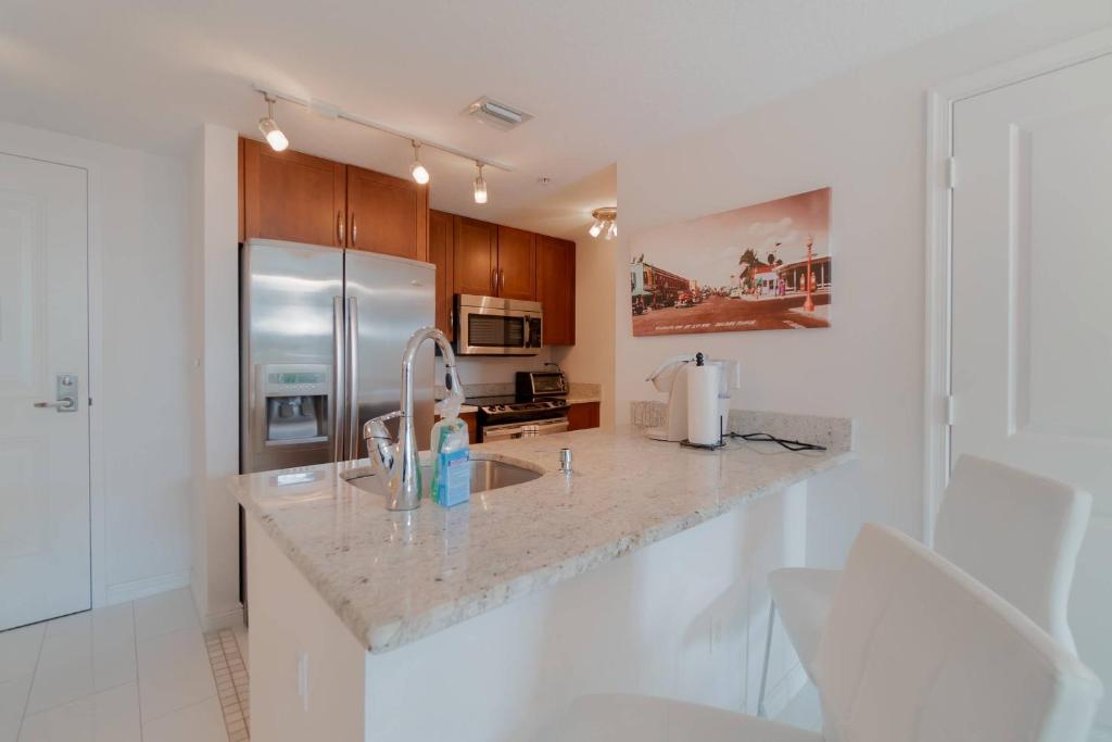 a kitchen with a sink and a stainless steel refrigerator at The Palms Suite - Casa Costa 309S 1 Bedroom, Pools, Jacuzzi, Beach, Shops & Dog Friendly in Boynton Beach
