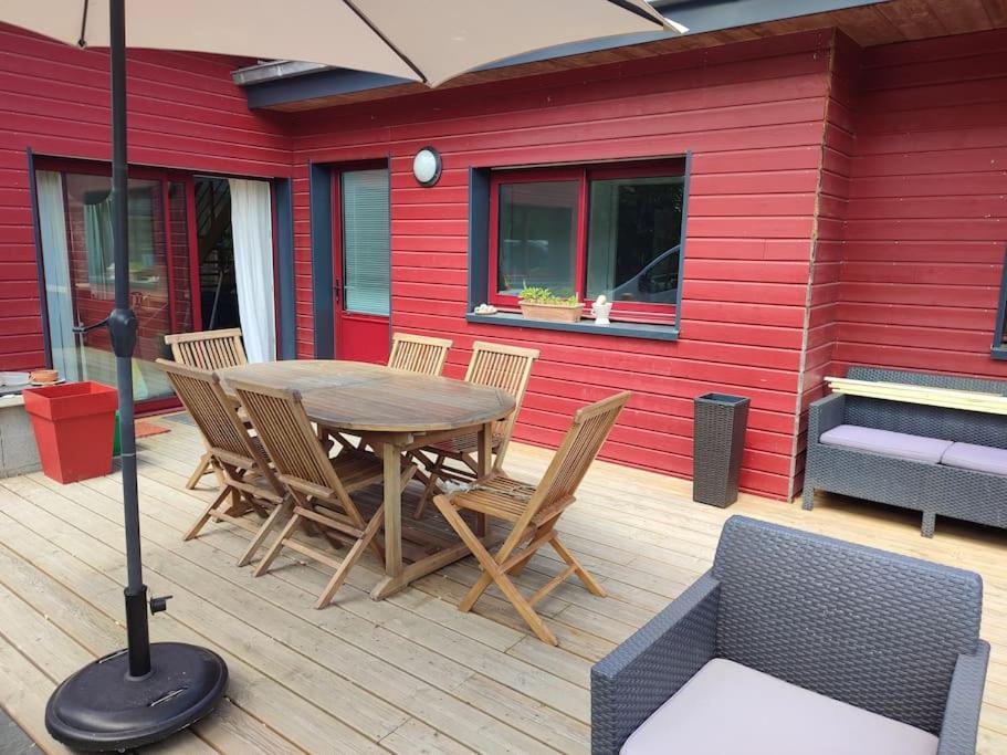 une table et des chaises en bois sur une terrasse en bois dans l'établissement Chez Gwen et Lulu - Maison en Bois - Trébeurden, à Trébeurden