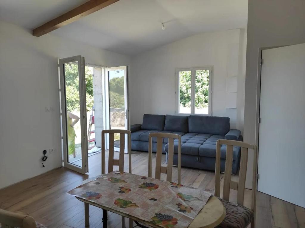 un salon avec un canapé bleu et une table dans l'établissement Maison charmante à Campsas avec terrasse et jardin, à Campsas