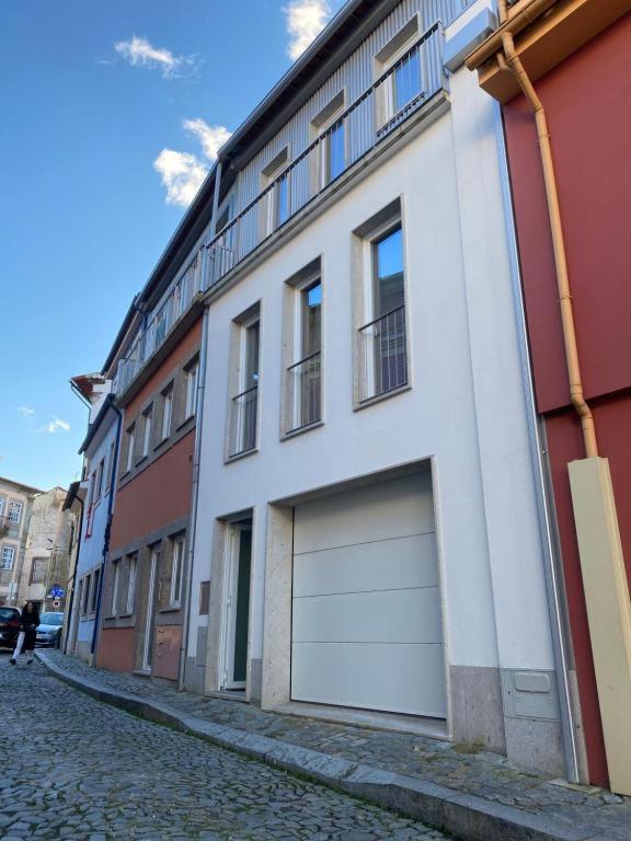 a white building with two garage doors on a street at Casa Augusta 4 in Braga