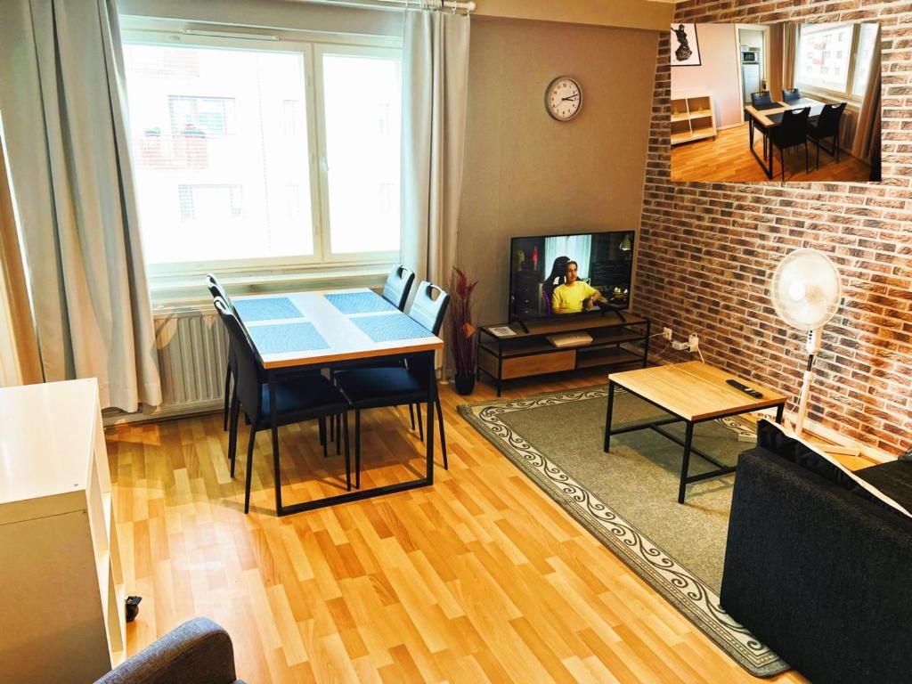 a living room with a table and a tv at Kemi City IV, near snowcastle, premium studio, FREE private parking, Special Price! in Kemi