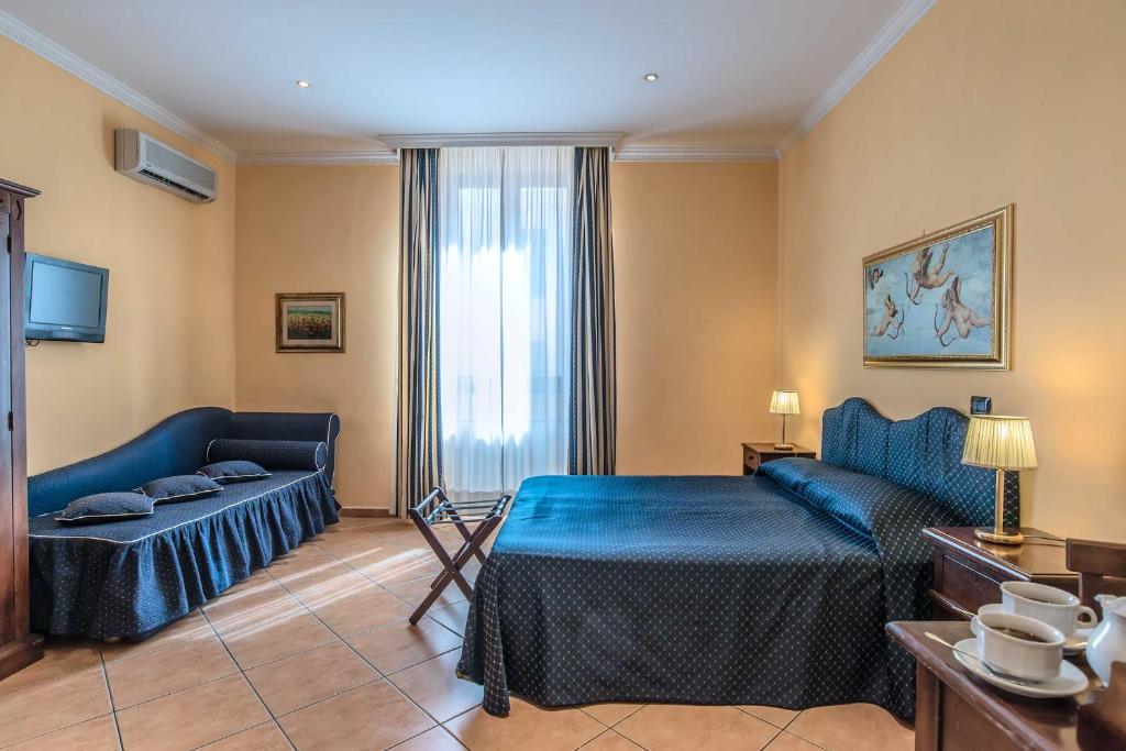 a hotel room with a bed and a couch at Hotel Caracciolo in Rome