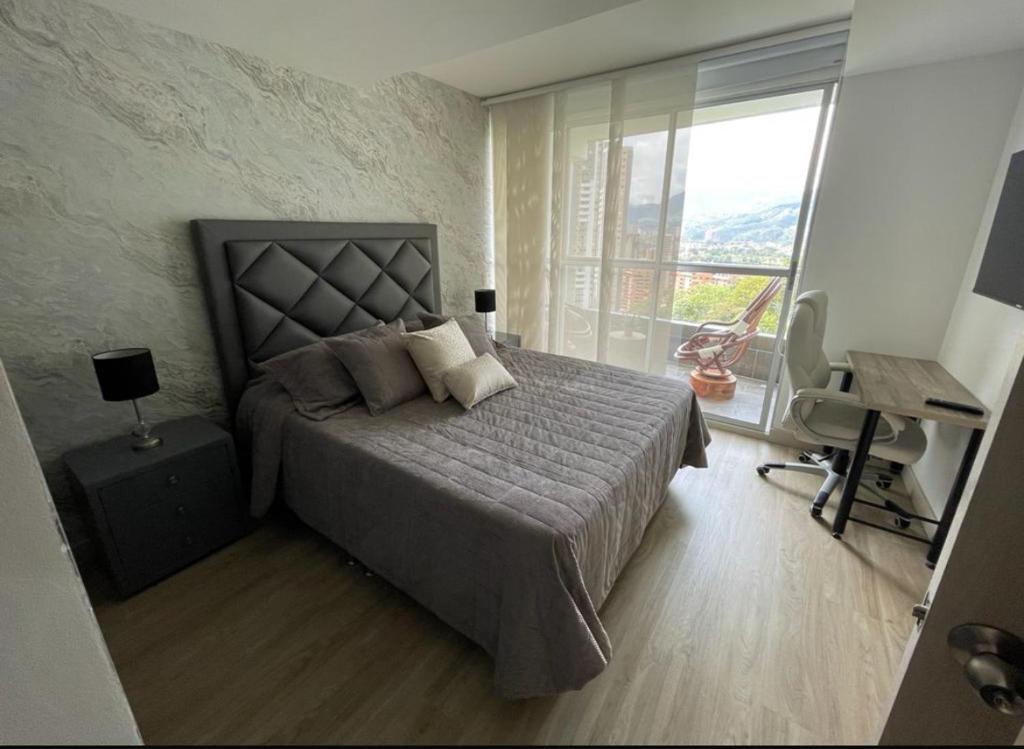 a bedroom with a large bed and a large window at Apartamento espectacular 3-4 habitaciones sabaneta in Sabaneta