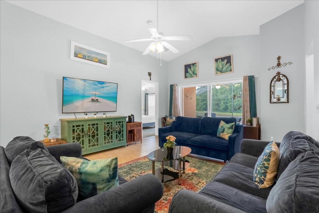 a living room with couches and a flat screen tv at Upstay Lakeside Retreat w Private Pool and Game Room in Davenport