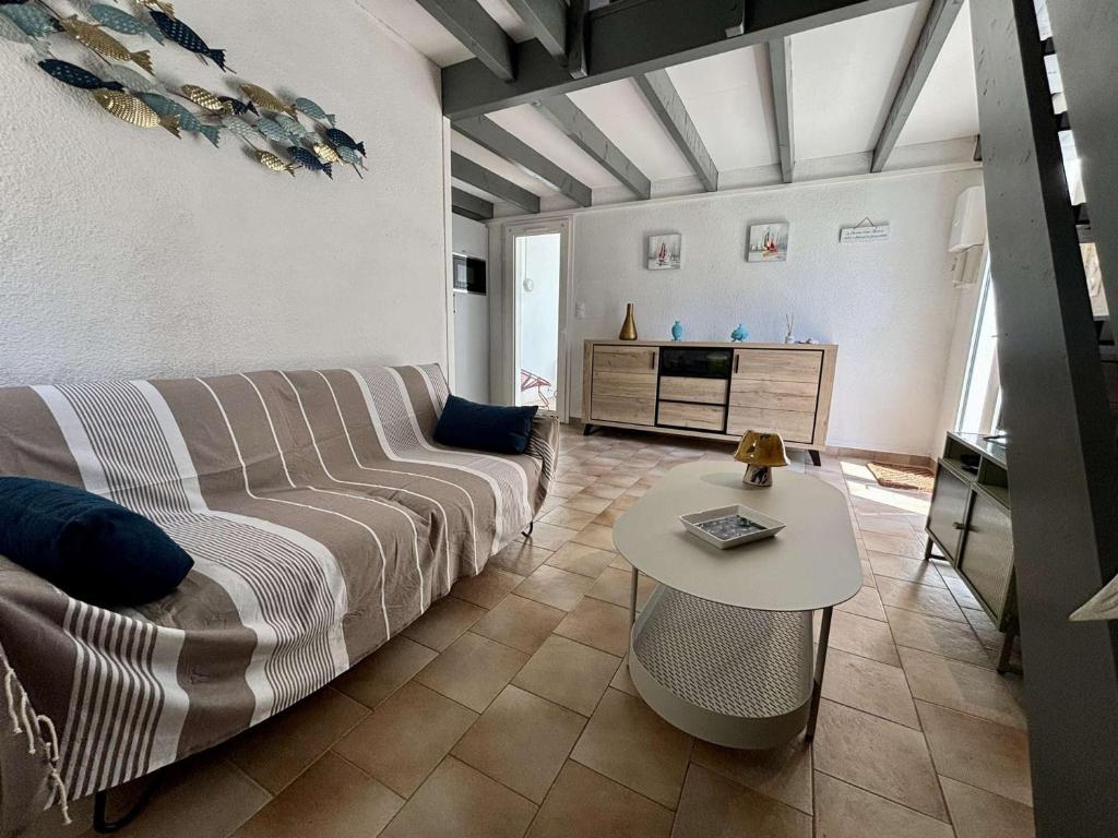 un salon avec un canapé et une table dans l'établissement Maison rénovée 2 pas plage Oléron, 4 couchages, WIFI, parking - FR-1-246A-331, à Saint-Georges-dʼOléron