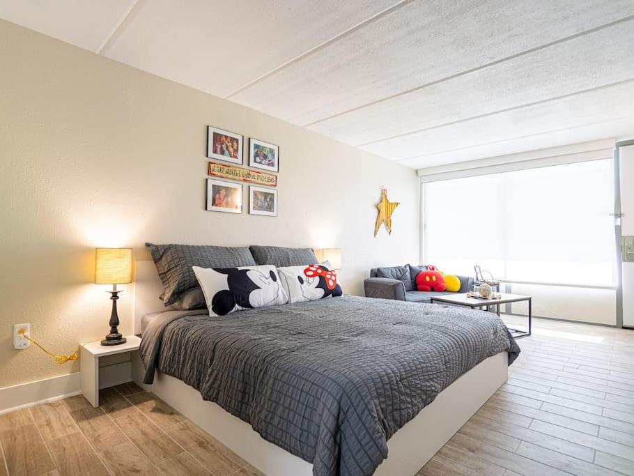 Un dormitorio con una cama grande y un sofá. en Orlando 1BR Disney Themed Vacation with pool view Next to Disney, en Kissimmee