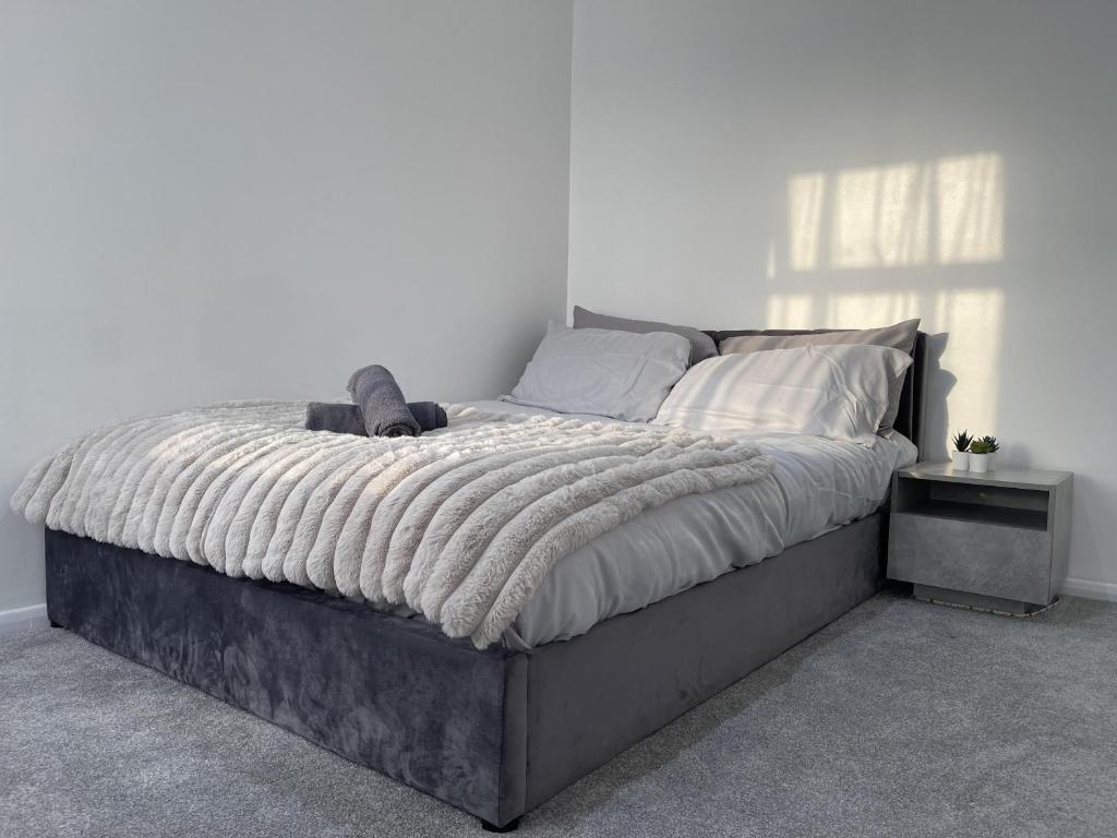 a bedroom with a large bed with a blanket at 3 Bed House - Sleeps 5 - Garden - Parking - Wifi in Dartford