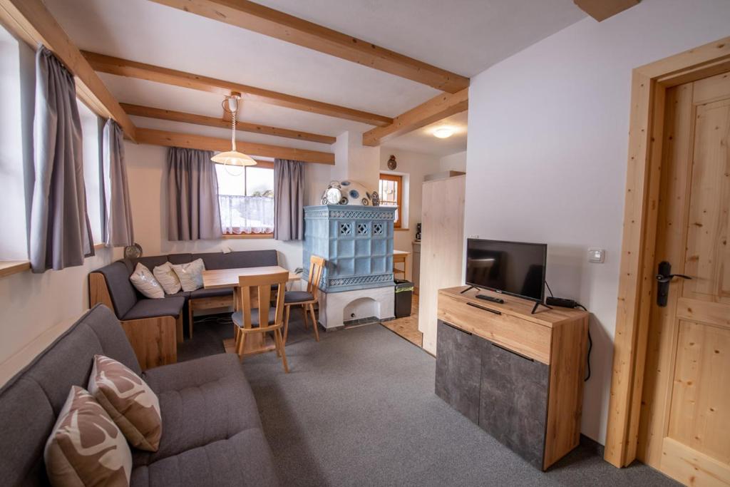 sala de estar con sofá, mesa y TV en Appartement Fürler UG, en Königsleiten