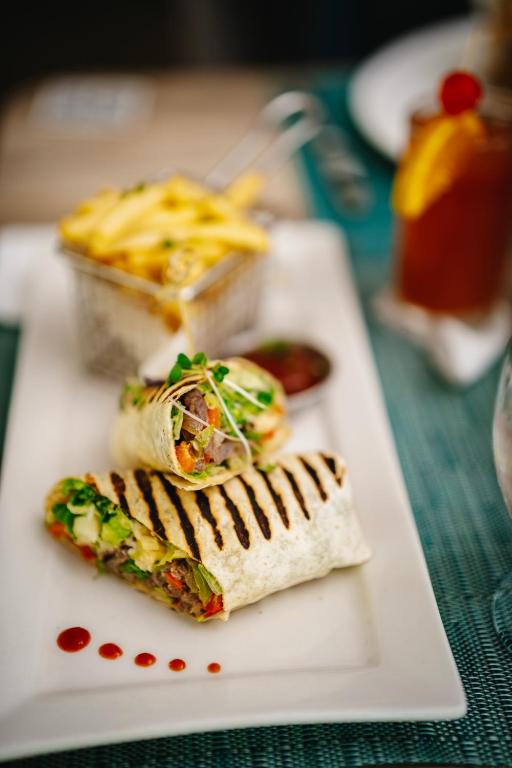 a white plate with food on a table at Coconut Court Beach Hotel in Bridgetown