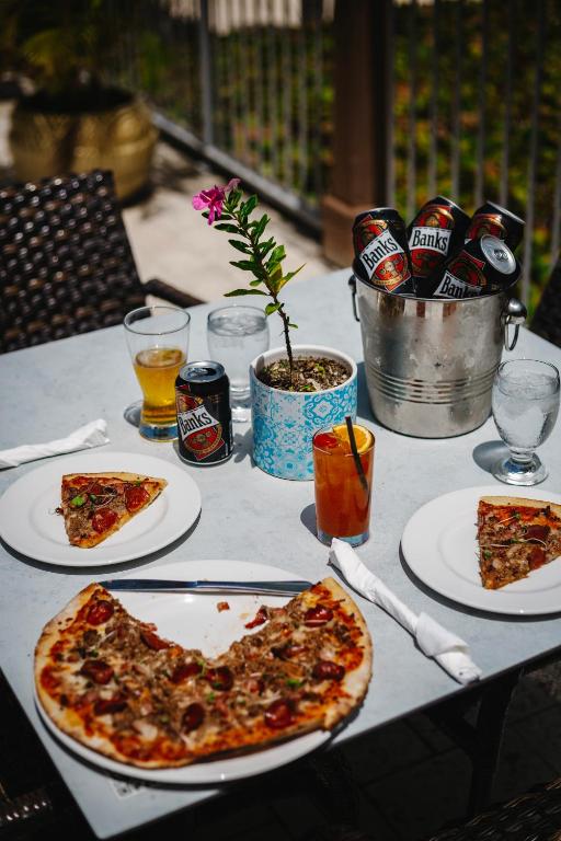 a table with two slices of pizza and soda at Coconut Court Beach Hotel in Bridgetown
