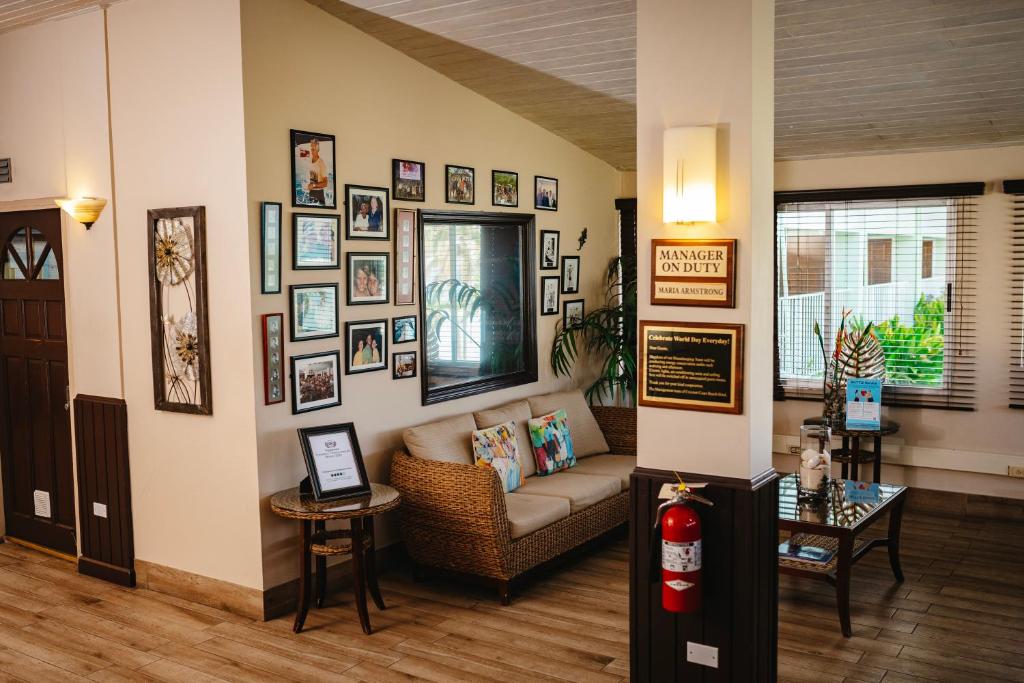 a living room with a couch and pictures on the wall at Coconut Court Beach Hotel in Bridgetown