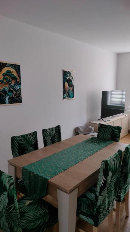 a table with green chairs and a desk with a computer at Apartament Tereska in Duszniki Zdrój
