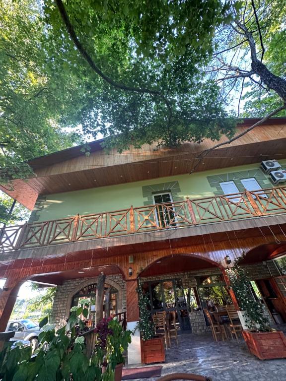 ein Gebäude mit einem Balkon mit Tischen und Stühlen in der Unterkunft Bar Restaurant Hotel Shinjatari in Klos