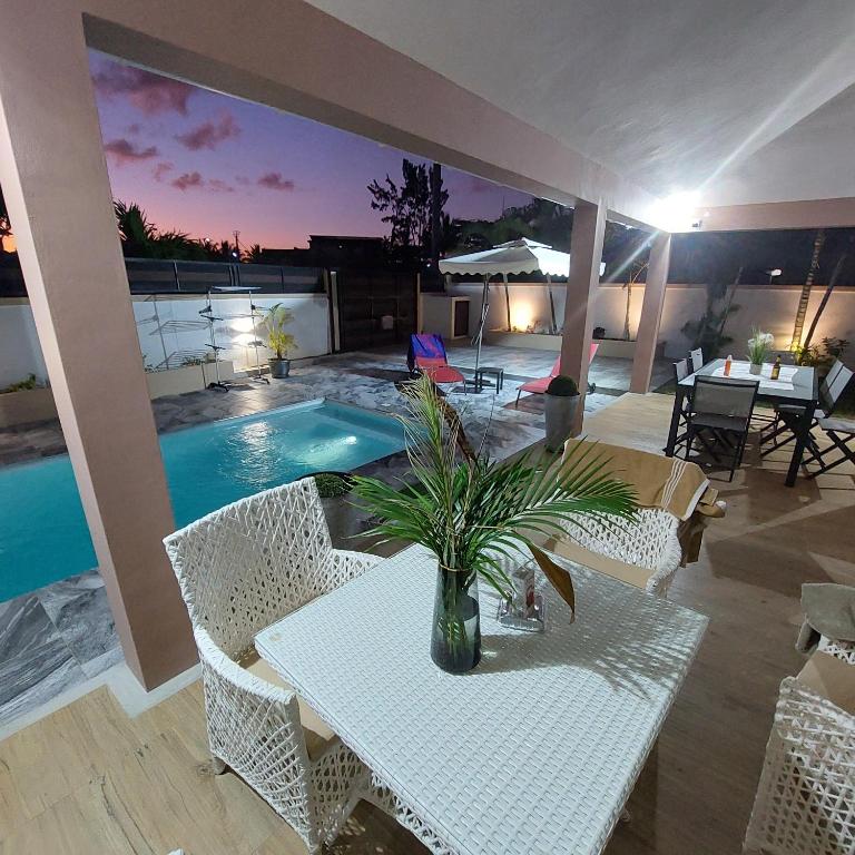 a patio with a table and chairs and a pool at Villa Le Mahé, Mahébourg in Mahébourg