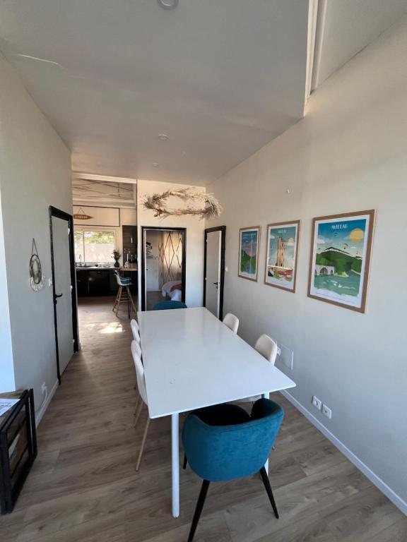 a dining room with a white table and chairs at La Verrière Berges du Tarn - Centre historique in Millau