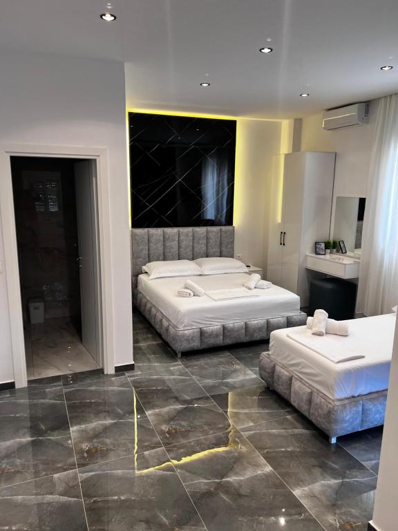 two beds in a hotel room with two bedsvisor at Nōya Suites SR in Sarandë