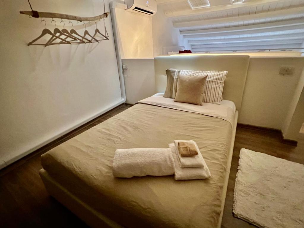 une petite chambre avec un lit avec des serviettes dessus dans l'établissement Loft Porto Romano Olbia Centro, à Olbia
