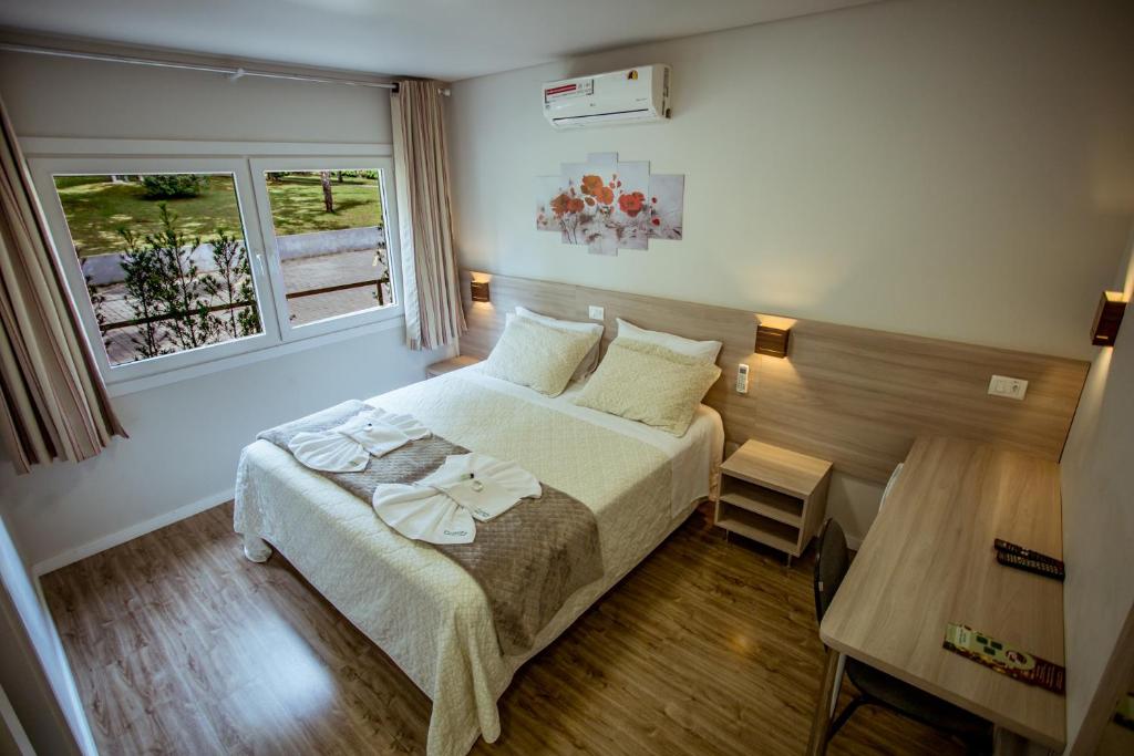 a bedroom with a bed and a window at Filadélfia Hospedagens e Eventos in São Bento do Sul