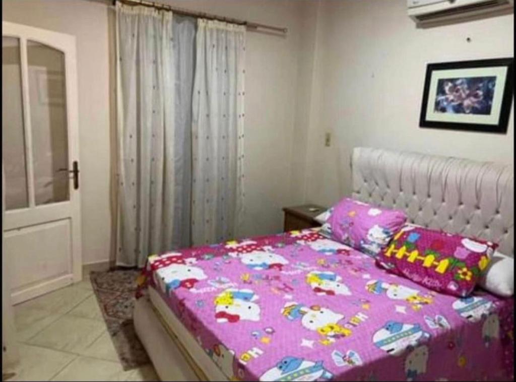 ein Schlafzimmer mit einem Bett mit einer rosa Decke in der Unterkunft Happy home in Hurghada