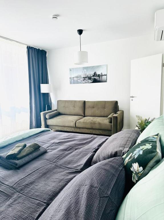 a bedroom with a bed and a couch at City Center Apartments Düsseldorf in Düsseldorf